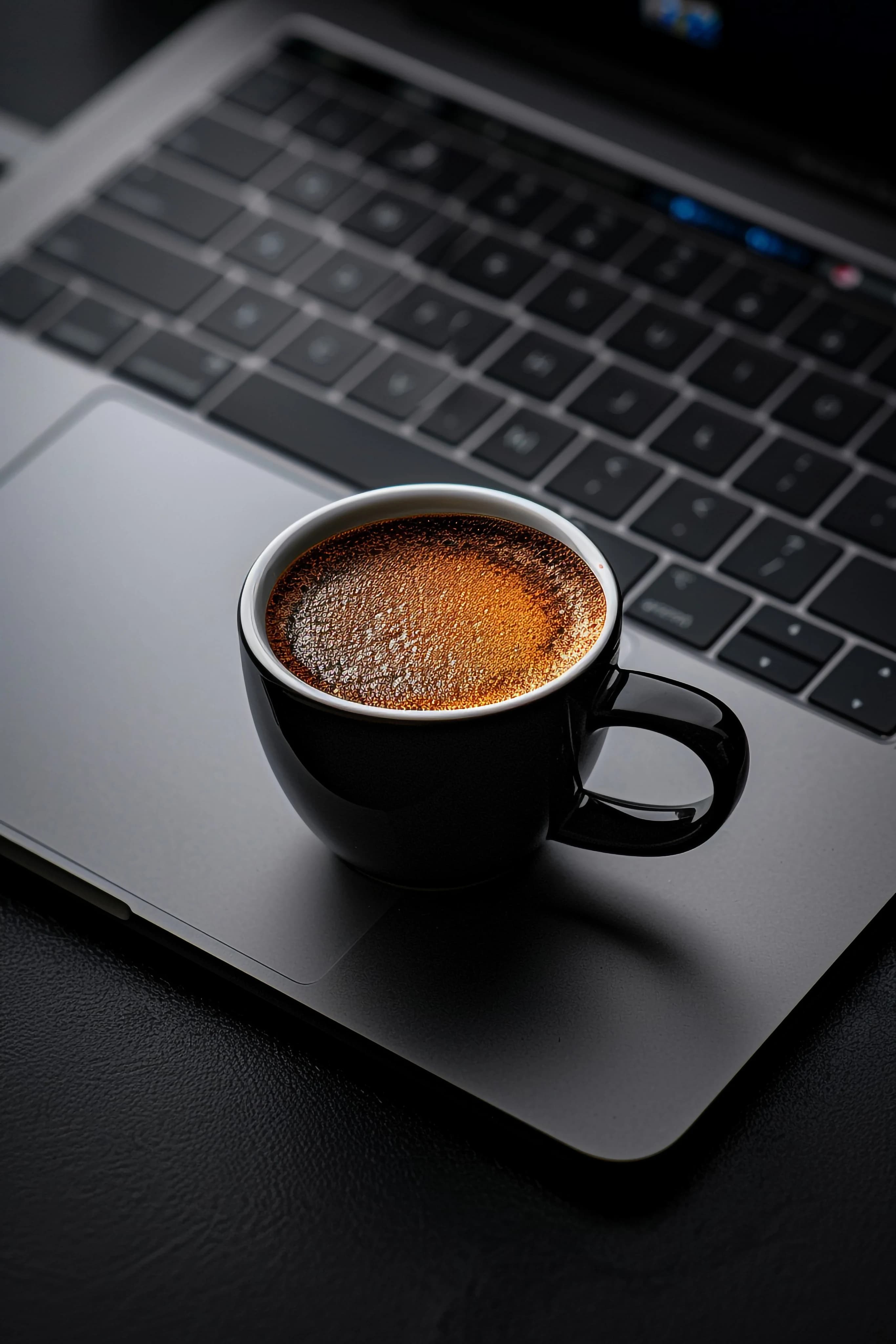 Taza de café junto a un teclado durante una jornada de operación tecnológica Taza de café junto a un teclado durante una jornada de operación tecnológica